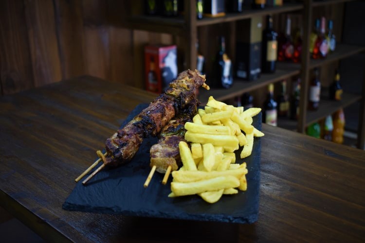 Brochetas de carne a la parrilla con papas fritas