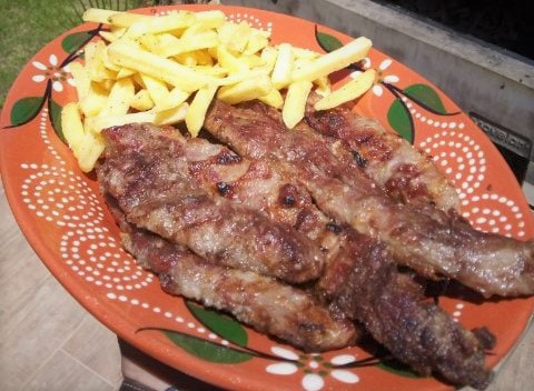 lagartos de cerdo servidos en un plato con papas fritas